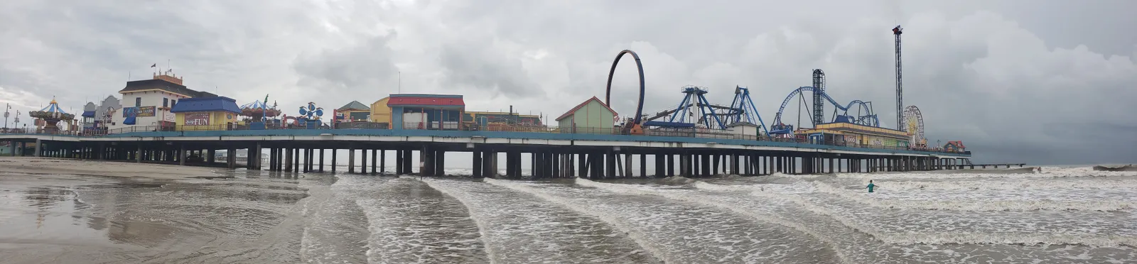 The Galveston Island Historic Pleasure Pier, with its rides and roller coaster, over the beach on the Gulf of Mexico